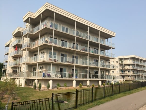 Exterior view of a four-storey apartment with balconies, overlooking the marina