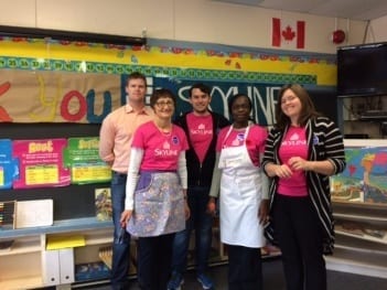 Five Skyliners pose in aprons after making snacks for children