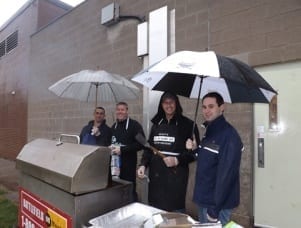 Four Skyline executives barbecue dinner under umbrellas