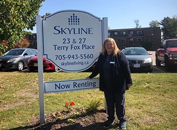 Woman standing next to building sign
